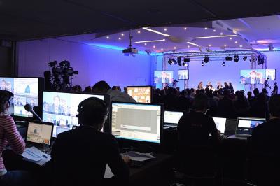 Dessert au chocolat garni de mangue, copeaux de noix de coco et pistaches, présenté sur une assiette verte.