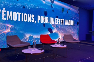 Dessert au chocolat garni de mangue, copeaux de noix de coco et pistaches, présenté sur une assiette verte.