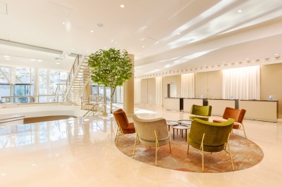 Dessert au chocolat garni de mangue, copeaux de noix de coco et pistaches, présenté sur une assiette verte.