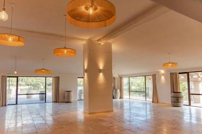 Un couple en tenue de mariage pose dans un champ d'oliviers sous une lumière douce.