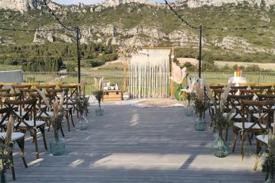 Un couple en tenue de mariage pose dans un champ d'oliviers sous une lumière douce.
