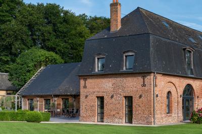 Banc en bois sous une arche décorée de feuilles d'automne, entouré de bougies et de feuilles au sol dans une salle rustique.