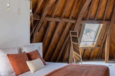 Banc en bois sous une arche décorée de feuilles d'automne, entouré de bougies et de feuilles au sol dans une salle rustique.