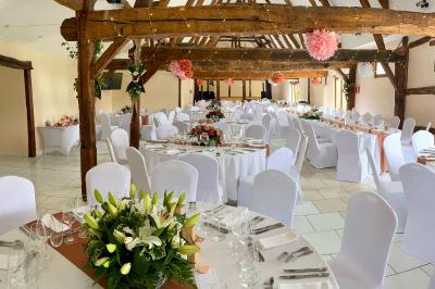 Lit double avec tête de lit sombre, draps gris et blancs, encadré par deux tables de chevet avec lampes, dans une chambre…