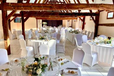 Lit double avec tête de lit sombre, draps gris et blancs, encadré par deux tables de chevet avec lampes, dans une chambre…