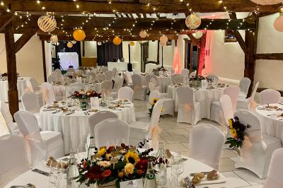 Lit double avec tête de lit sombre, draps gris et blancs, encadré par deux tables de chevet avec lampes, dans une chambre…