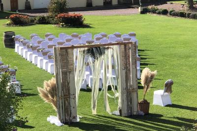 Lit double avec tête de lit sombre, draps gris et blancs, encadré par deux tables de chevet avec lampes, dans une chambre…