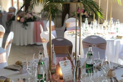 Lit double avec tête de lit sombre, draps gris et blancs, encadré par deux tables de chevet avec lampes, dans une chambre…