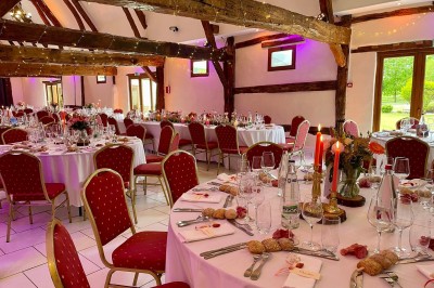 Table garnie de pâtisseries, macarons, fruits et biscuits, disposée en extérieur avec un jardin en arrière-plan.