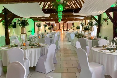 Table garnie de pâtisseries, macarons, fruits et biscuits, disposée en extérieur avec un jardin en arrière-plan.
