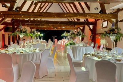 Miniature Location salle Argueil (Seine-Maritime) - Domaine de Clairval #17 Salle de réception décorée avec des tables rondes dressées, chaises blanches et guirlandes lumineuses suspendues.