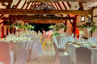 Miniature Location salle Argueil (Seine-Maritime) - Domaine de Clairval #21 Salle de réception décorée avec des tables rondes dressées, chaises blanches et guirlandes lumineuses suspendues.