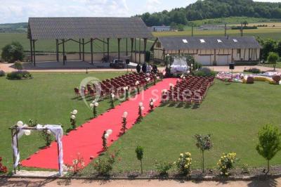 Lit double avec tête de lit sombre, draps gris et blancs, encadré par deux tables de chevet avec lampes, dans une chambre…