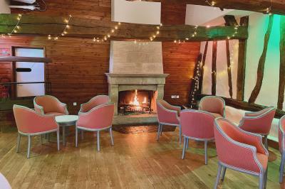 Lit double avec tête de lit sombre, draps gris et blancs, encadré par deux tables de chevet avec lampes, dans une chambre…