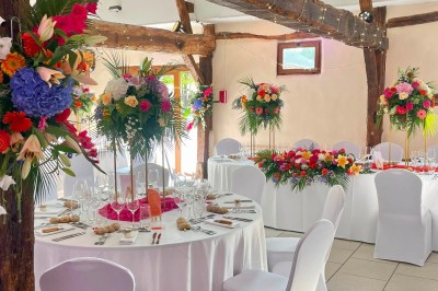 Table garnie de pâtisseries, macarons, fruits et biscuits, disposée en extérieur avec un jardin en arrière-plan.