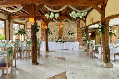 Table garnie de pâtisseries, macarons, fruits et biscuits, disposée en extérieur avec un jardin en arrière-plan.
