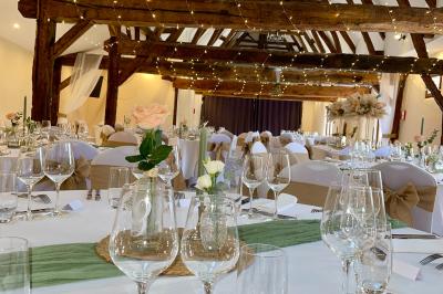 Lit double avec tête de lit sombre, draps gris et blancs, encadré par deux tables de chevet avec lampes, dans une chambre…