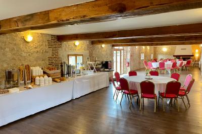 Table garnie de pâtisseries, macarons, fruits et biscuits, disposée en extérieur avec un jardin en arrière-plan.
