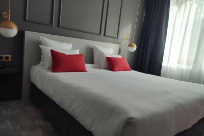 Piscine intérieure avec carrelage bleu, transats colorés et grandes baies vitrées laissant entrer la lumière naturelle.