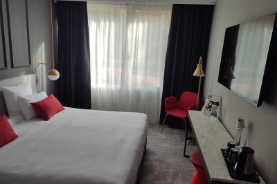 Piscine intérieure avec carrelage bleu, transats colorés et grandes baies vitrées laissant entrer la lumière naturelle.