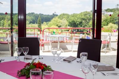 Piscine intérieure avec carrelage bleu, transats colorés et grandes baies vitrées laissant entrer la lumière naturelle.