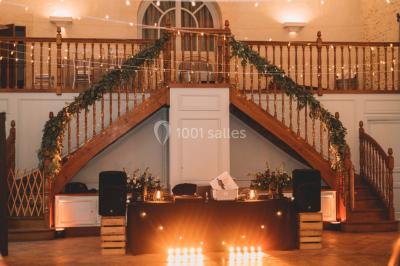 Groupe de personnes rassemblées dans un jardin près d'une bâtisse ancienne, sous une tente blanche par temps clair.