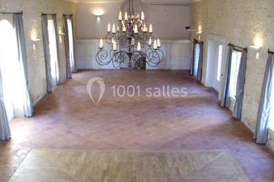 Groupe de personnes rassemblées dans un jardin près d'une bâtisse ancienne, sous une tente blanche par temps clair.
