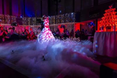 Un couple en tenue de mariage danse au milieu d'une salle de casino entourée de machines à sous.