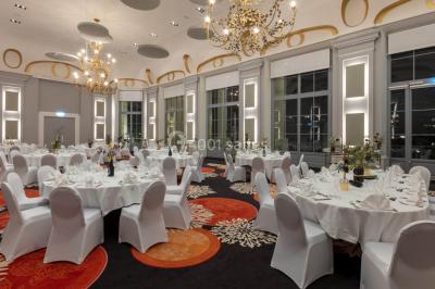 Un couple en tenue de mariage danse au milieu d'une salle de casino entourée de machines à sous.