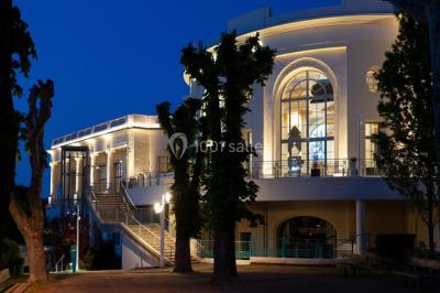 Un couple en tenue de mariage danse au milieu d'une salle de casino entourée de machines à sous.