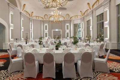 Un couple en tenue de mariage danse au milieu d'une salle de casino entourée de machines à sous.