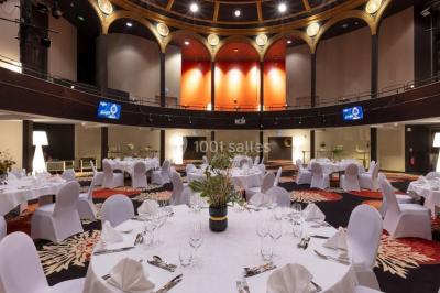 Un couple en tenue de mariage danse au milieu d'une salle de casino entourée de machines à sous.