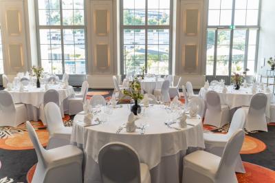 Un couple en tenue de mariage danse au milieu d'une salle de casino entourée de machines à sous.