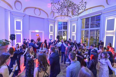 Un couple en tenue de mariage danse au milieu d'une salle de casino entourée de machines à sous.