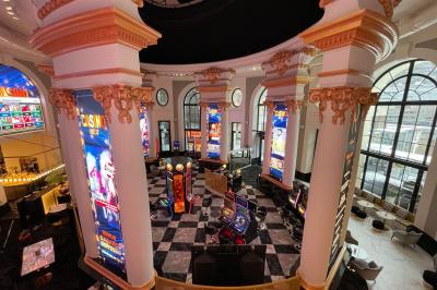 Un couple en tenue de mariage danse au milieu d'une salle de casino entourée de machines à sous.