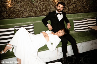 Un couple en tenue de mariage danse au milieu d'une salle de casino entourée de machines à sous.