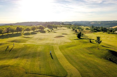 Miniature Location salle Saint-Médard-d'Excideuil (Dordogne) - Domaine d'Essendiéras #9 Vue aérienne d'un terrain de golf verdoyant avec des arbres alignés et un paysage vallonné sous un ciel ensoleillé.
