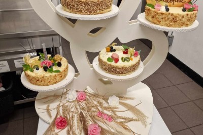 Choux noirs garnis de crème blanche et décorés de filet de caramel, disposés sur une surface métallique.