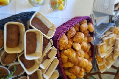 Choux noirs garnis de crème blanche et décorés de filet de caramel, disposés sur une surface métallique.