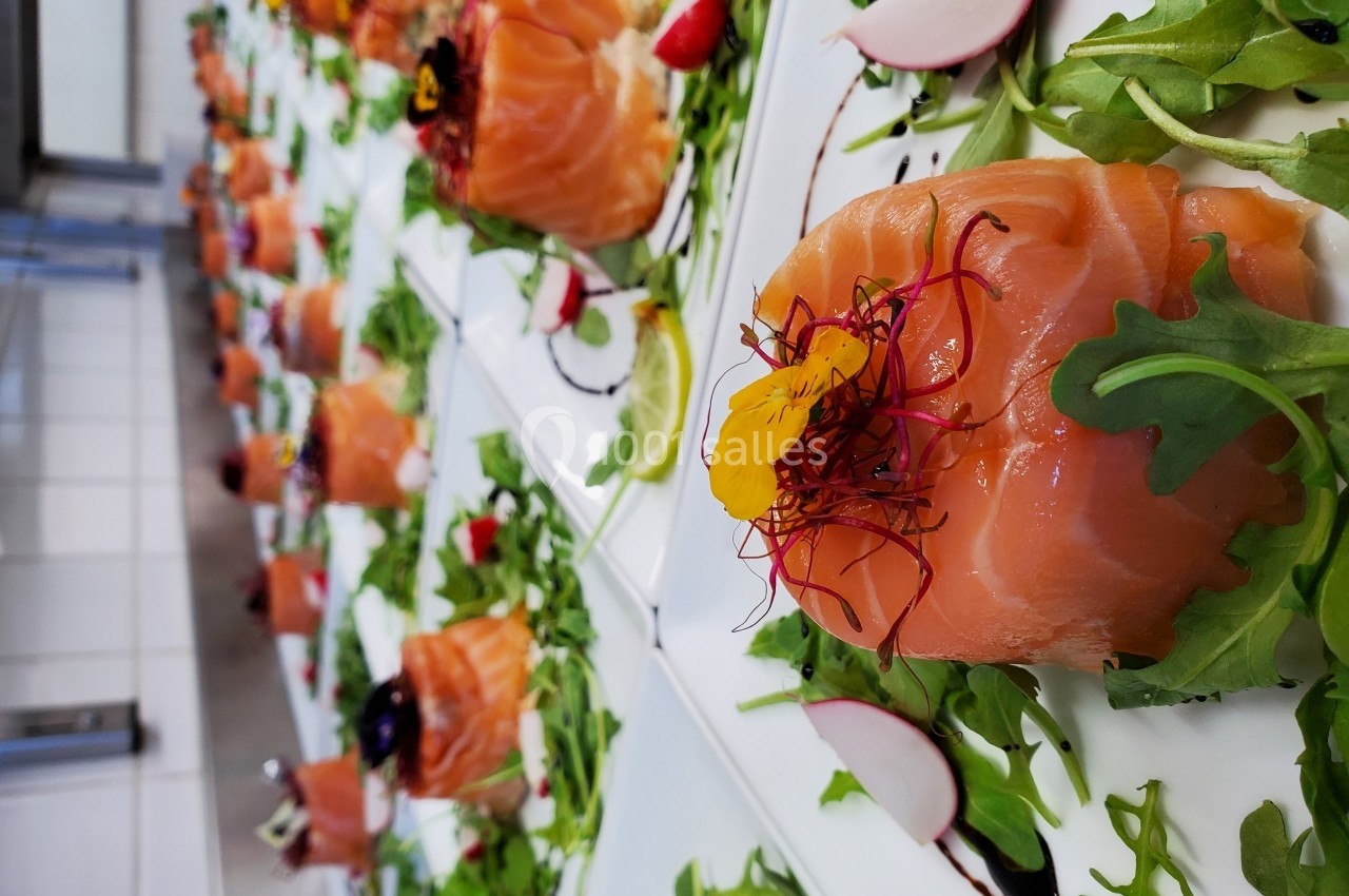 Assiettes de saumon fumé garnies de roquette, radis, fleurs comestibles et filet de vinaigre balsamique.