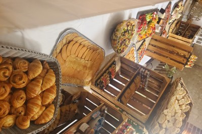 Choux noirs garnis de crème blanche et décorés de filet de caramel, disposés sur une surface métallique.