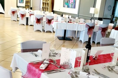 Choux noirs garnis de crème blanche et décorés de filet de caramel, disposés sur une surface métallique.