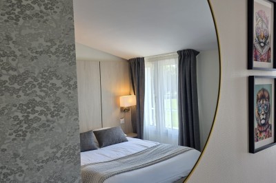 Choux noirs garnis de crème blanche et décorés de filet de caramel, disposés sur une surface métallique.