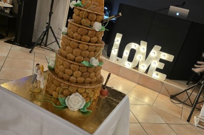Salle de restaurant lumineuse avec tables dressées, chaises en bois sombre, étagères décoratives et plantes vertes.