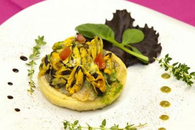 Camion noir de traiteur ’Le Quai Fleuri’ garé devant un bâtiment, avec visuels de prestations culinaires sur les panneaux.