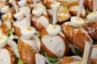 Camion noir de traiteur ’Le Quai Fleuri’ garé devant un bâtiment, avec des visuels de prestations culinaires.