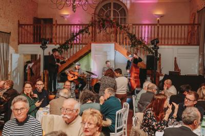 Écran lumineux affichant des images colorées dans un jardin fleuri à la tombée de la nuit.