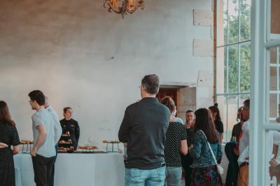Écran lumineux affichant des images colorées dans un jardin fleuri à la tombée de la nuit.