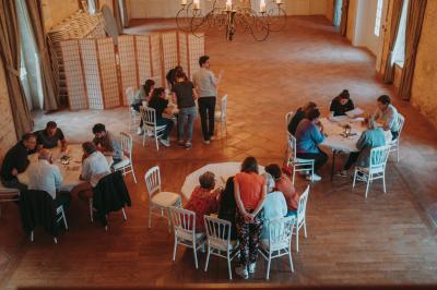 Écran lumineux affichant des images colorées dans un jardin fleuri à la tombée de la nuit.