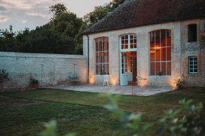 Écran lumineux affichant des images colorées dans un jardin fleuri à la tombée de la nuit.